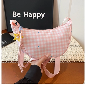 Vue détaillée du sac croissant à carreaux rose et blanc avec breloque étoile sur dentelle