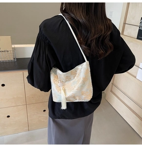 Detailed view of jacquard shoulder bag with Chinese landscape pattern and white silk tassel