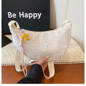 Détail du sac demi-lune à carreaux jaunes avec breloque étoile et cordon tressé rose