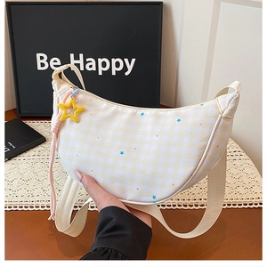 Détail du sac dumpling à carreaux jaunes avec imprimé étoile et large bandoulière