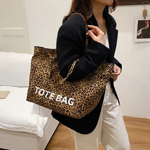 Große Shopper-Tasche mit Leopardenmuster und weißem TOTEBAG-Schriftzug von Model getragen