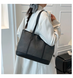 Detail of contrast stitch large canvas tote bag with black leather base and slim straps