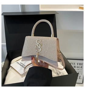Dettaglio della borsa glitter champagne con logo SS in metallo e nappa elegante