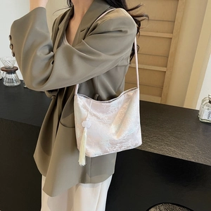 Minimalist jacquard bucket bag with silk texture and elegant tassel for 2025 fashion