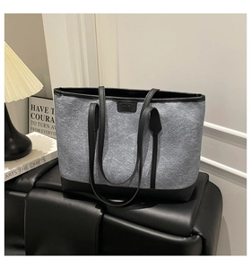 Detailed view of gray felt tote bag with black leather base on a stylish seat