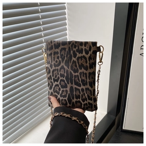 Detail showing leopard print texture and gold chain strap of the stylish crossbody bag