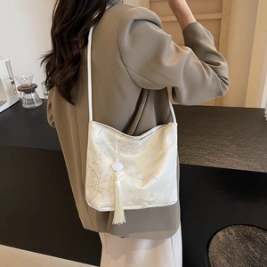 Chic jacquard bucket bag with bamboo patterns and long tassel shown on model
