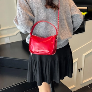Glossy red half-moon handbag with gold chain strap and fashion logo patch for women