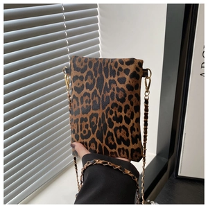 Detail of leopard print mini crossbody bag with golden chain strap for modern styling