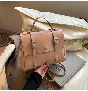 Close-up of beige faux leather backpack with retro flap and buckle closure design