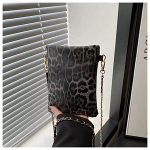 Close-up of leopard print crossbody bag with gold chain strap and textured PU material
