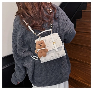 Checkered white backpack with cartoon animal print and plush bear charm on a model