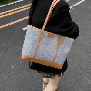 Chic felt and leather tote bag with large capacity shown in a stylish street style pose