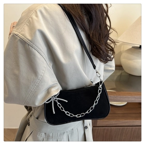 Détail du sac bandoulière en daim noir avec chaîne argentée épaisse et pendentif étoile