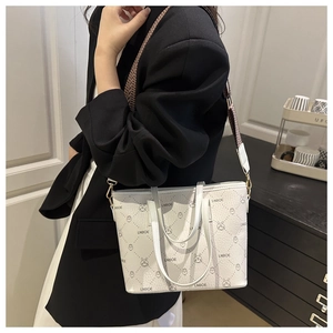 Detail of white printed bucket bag with wide geometric strap and gold hardware