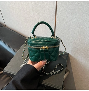 Detailed macro view of small green quilted leather vanity bag with gold chain strap