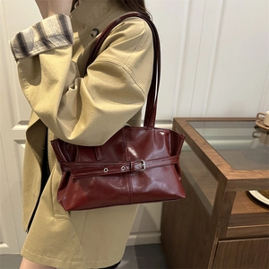 Retro burgundy tote bag with metal buckle and glossy patent finish on model