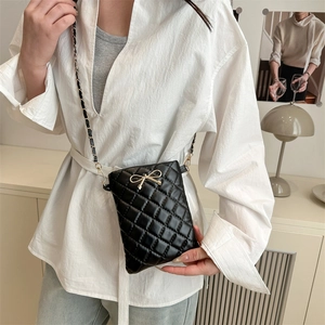 Classic black quilted crossbody bag with golden bow hardware and chain strap