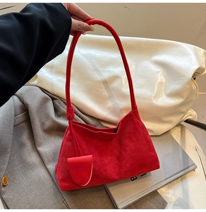 Macro view of red suede hobo bag texture with a matching decorative heart charm