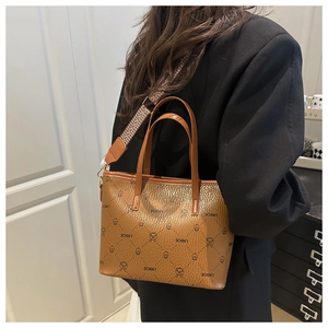 Brown leather bucket bag with tiger print patterns and a woven ethnic style shoulder strap