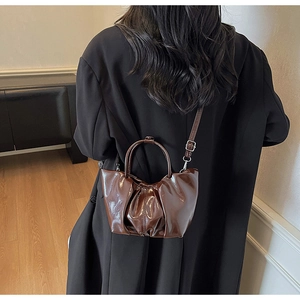 Deep brown pleated cloud bag with shiny leather texture and silver hardware details