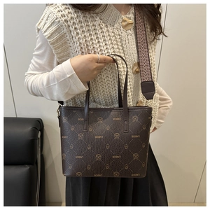 Detail of dark brown bucket bag with monogram pattern and woven shoulder strap