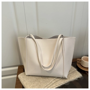 Close-up of minimalist large tote bag in beige leather on soft wool scarf for daily use