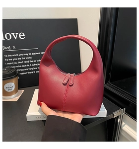 Detail of dark red hobo bag with dual zippers and smooth matte leather texture