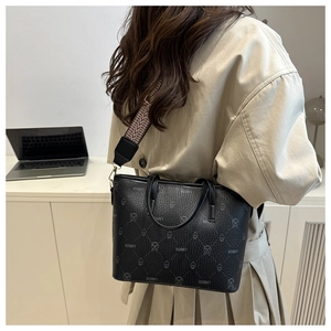Detail of black monogram bucket bag with geometric patterned wide shoulder strap