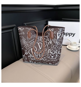Close-up of graffiti patterns including cats and hearts on a brown tote bag surface