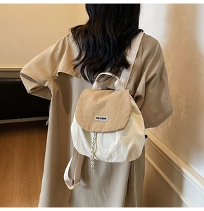 Rear view of a model wearing the small color-block canvas backpack in beige and khaki