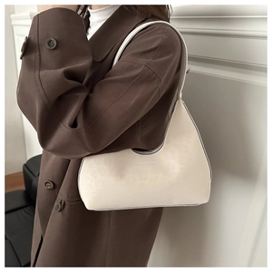 Detail der minimalistischen cremeweißen Hobo-Schultertasche mit geprägter Textur