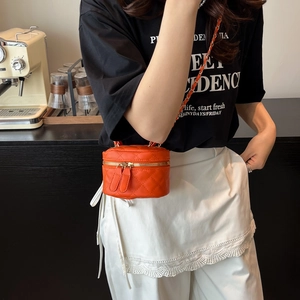 Quilted bright orange mini cylinder crossbody bag with woven chain strap and dual zipper