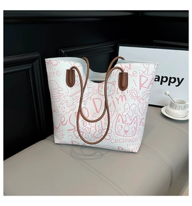 Detail of artistic graffiti tote bag with pink cat prints and brown double handles