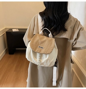 Detail of Korean-style nylon backpack showing drawstrings and contrast color flap