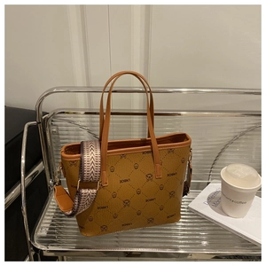 Close-up of brown faux leather bucket bag with bear print and wide patterned shoulder strap
