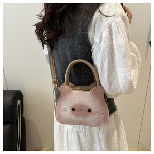 Fille portant un sac bandoulière chat rose et blanc sur un gilet en maille gris
