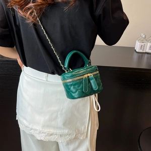 Dark green quilted mini vanity bag with chain strap shown on model for style