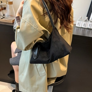 Retro black suede-like shoulder bag with leather strap shown in a lifestyle street setting