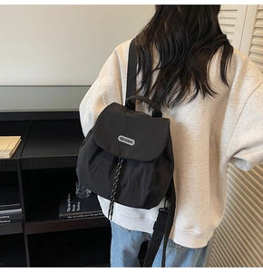 Detail showing the rubber brand logo and decorative drawstring on this nylon backpack