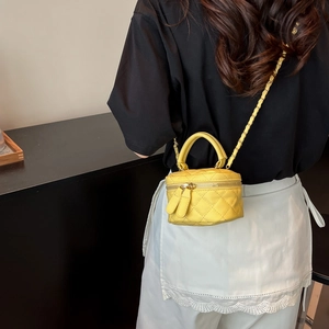 Chic bright yellow quilted leather mini vanity bag with golden chain strap on model