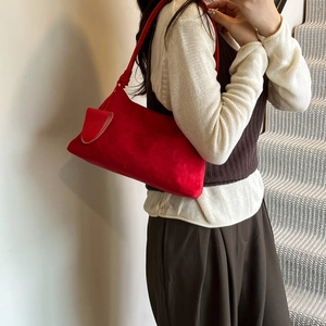 Red suede rectangular underarm shoulder bag for women styled in an indoor setting