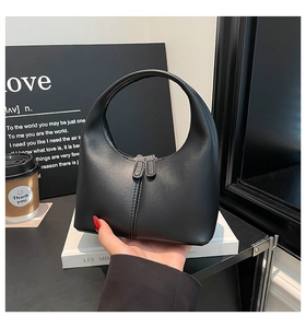 Detail view of smooth black leather hobo bag with dual zipper closure and sleek silhouette