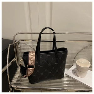 Detail of black textured bucket bag with cartoon pattern and retro wide shoulder strap