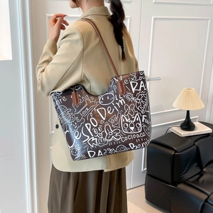 Graffiti print tote bag in dark brown PU leather shown on a model for daily styling