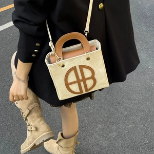 Borsa a tracolla in tela e pelle marrone con logo AB circolare in un look stile street