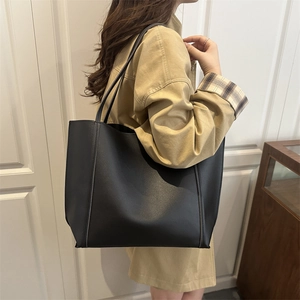 Minimalist large black faux leather tote bag for women showing daily wear style