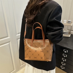 Brown bucket bag with LNBOE print and jacquard strap shown on a black blazer