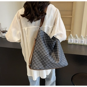 Detail of geometric pattern tote bag with leather straps and silver side zipper pocket