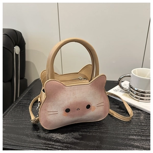 Détail d'un sac à bandoulière en forme de chat avec dégradé rose sur un bureau chic